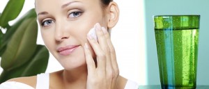 Woman holding moisturizer cream and applying it on her face